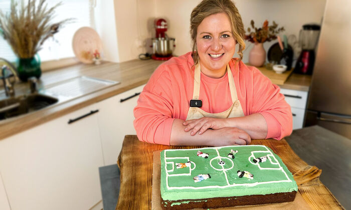 Rezepte & Inspirationen: Monika Nagl zeigt lächelnd ihre Fußballtorte mit Butter und Mascarpone zur EM von GOLDSTEIG. 