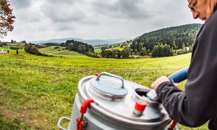 Milchsammelwagen-Fahrer saugt milch aus mobilem Milchtank