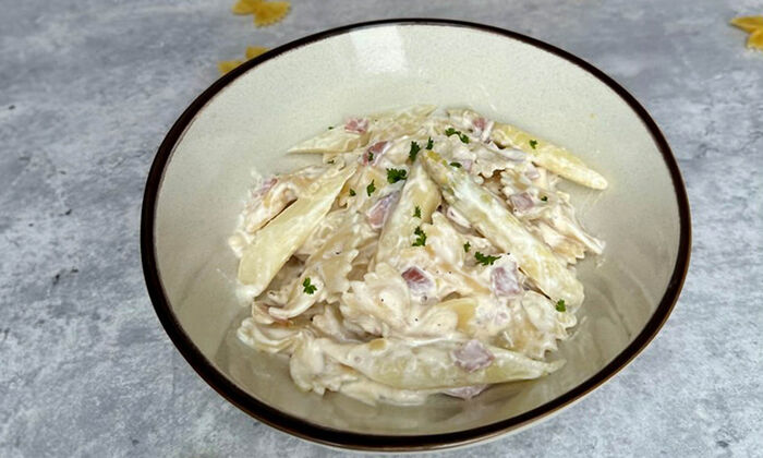 Rezepte & Inspirationen: Spargel Pasta mit Ricotta von GOLDSTEIG in einem weißen Teller mit schwarzem Rand.