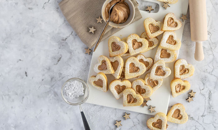 Rezepte & Inspirationen: Banoffee-Herzen Rezept mit Butter von GOLDSTEIG auf weißem Brett.