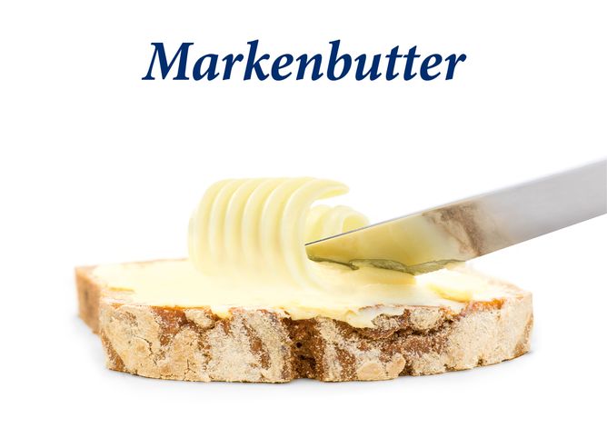 Markenbutter von GOLDSTEIG wird mit einem Messer auf ein Brot gestrichen