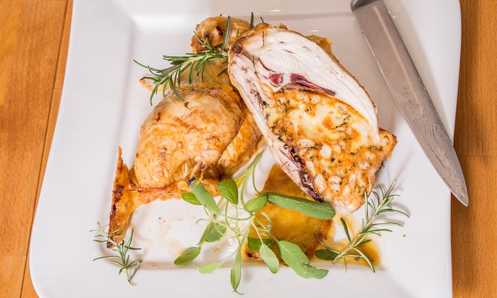 Almdammer Rezept Gebackenes Hähnchen mit Semmel-Almdammer-Füllung und Kräuter von GOLDSTEIG auf Teller