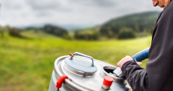 Milchsammelwagen-Fahrer saugt Milch aus mobilem Milchtank