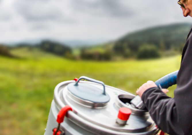 Milchsammelwagen-Fahrer saugt Milch aus mobilem Milchtank