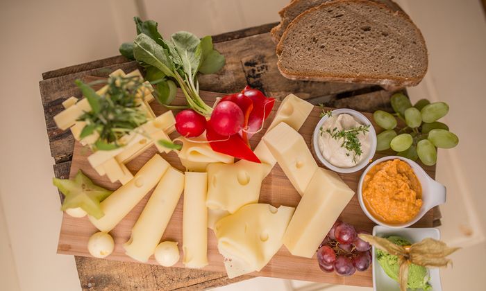 Emmentaler Rezept Käsebrett mit verschiedenen Käsesorten und Butter von GOLDSTEIG, Brot, Dips wie Cashewcreme und Obazda, Gemüse und Obst auf Holzbrett