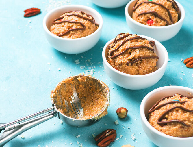 Cookie Dough in Porzellanschälchen mit Schokoladensoße und Nüssen garniert