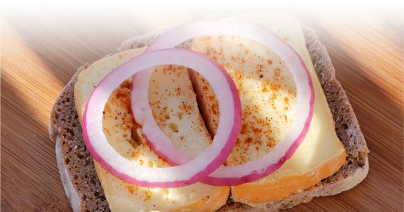 Limburger von GOLDSTEIG auf Vollkorn-Roggenbrot mit Zwiebelringen auf Holztisch