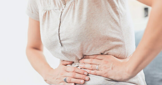 Schließt Käse wirklich den Magen? – Frau die sich den Bauch hält