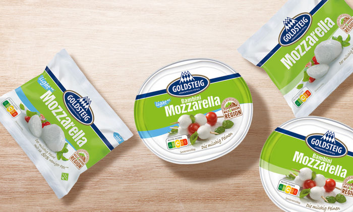 Mozzarella Sortiment von GOLDSTEIG auf Holztisch: Mozzarella Kugel light, Mozzarella Kugel classic, Bambini Mozzarella classic und Bambini Mozzarella light