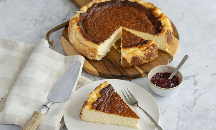 Rezepte & Inspirationen: Käsekuchen mit Ricotta von GOLDSTEIG auf Holzbrett.