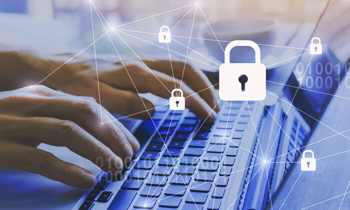 Zu Ihrer Bewerbung/personenbezogene Daten: Ein Mensch tippt auf seinem Laptop und im Vordergrund sieht man viele Schlüssel Schlösser.