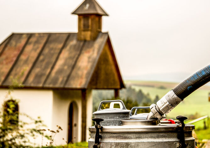 Milchabholung, im Hintergrund kleine Kapelle