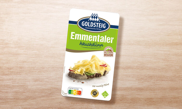 Emmentaler Scheiben hauchdünn - GOLDSTEIG Käsespezialitäten Emmentaler Scheiben hauchdünn von GOLDSTEIG in Verpackung auf Holztisch