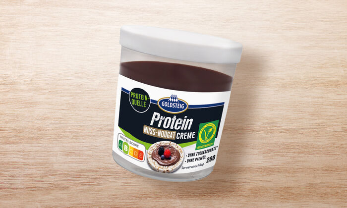 Protein Nuss-Nougat Creme von GOLDSTEIG in Verpackung auf Holztisch
