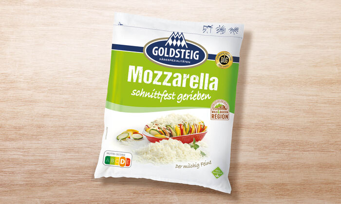 Mozzarella gerieben - GOLDSTEIG Käsespezialitäten Mozzarella gerieben von GOLDSTEIG in Verpackung auf Holztisch