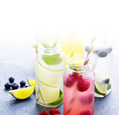 Selbstgemachte Limonade in den Geschmacksrichtungen Limette und Himbeere in Gläsern und mit frischen Früchten garniert