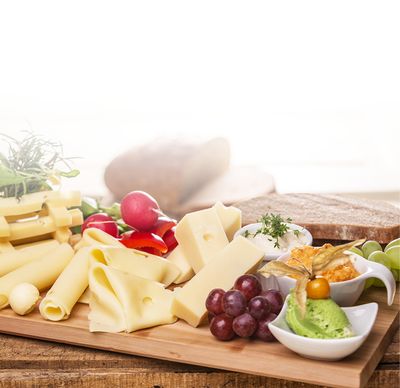 Emmentaler Rezept Käsebrett mit verschiedenen Käsesorten und Butter von GOLDSTEIG, Brot, Dips wie Cashewcreme und Obazda, Gemüse und Obst auf Holzbrett