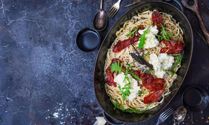 Rezepte & Inspirationen: Mediterrane Linguine mit geröstetem Schinken und Mozzarella von GOLDSTEIG in schwarzer Auflaufform.