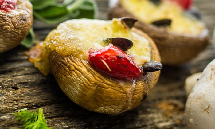 Almdammer Rezept Mit Almdammer und Bambini Mozzarella Mini mit Kräuter von GOLDSTEIG gefüllte Champignon mit Kräuter, Erdbeeren und Kürbiskerne auf Holzbrett