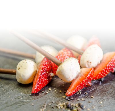 Mozzarella Rezept Bambini Mozzarella Mini von GOLDSTEIG mit Erdbeeren auf Schokoladensticks auf Schieferplatte