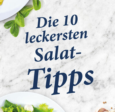 Zehn Salattipps von GOLDSTEIG auf Holzplatte mit Salatteller und Basilikum