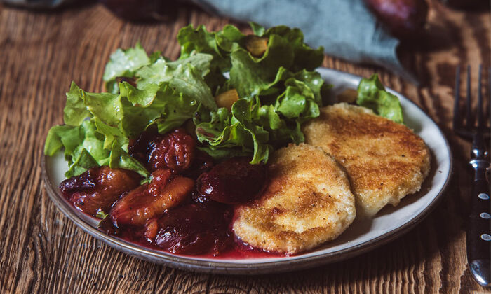 Rezepte & Inspirationen: Mozzarella gebacken mit marinierten Zwetschgen von GOLDSTEIG auf grauem Teller.