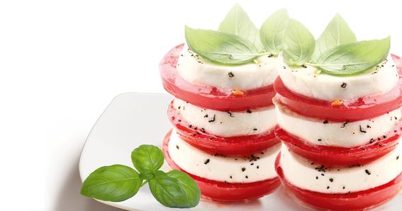 Mozzarella und Tomaten zu zwei Türmen geschichtet und mit Basilikum garniert