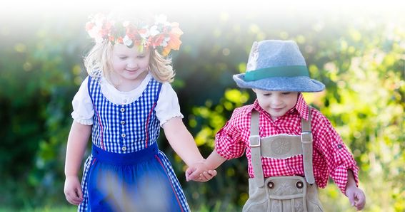 Zwei Kinder in Tracht Hand in Hand in der Natur