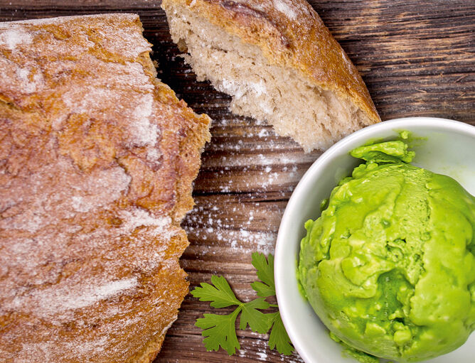 Petersilien-Cashewkern-Dip mit Butter von GOLDSTEIG und Brot auf Holzbrett 